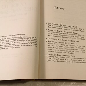 May include: A book cover with the title "The Home Gardener's Guide to Trees and Shrubs" and a table of contents listing the chapters: "The Garden - Delight or Dilemma?", "Trees and Shrubs - What and Where", "Using Plants to Solve Site Problems", "Shrubs and How to Select Them", and "Trees and How to Select Them".
