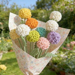 May include: A colourful bouquet of crocheted flowers, featuring yellow, orange, white, green, teal, purple, and pink blooms. The flowers are wrapped in floral paper, with green stems and leaves, a charming handmade gift.