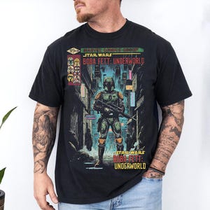 Puede incluir: Camiseta negra con un gr&aacute;fico de Boba Fett de Star Wars: Underworld. El dise&ntilde;o incluye el texto "Marvel Comics Group" y "Star Wars" sobre la ilustraci&oacute;n del personaje. La obra de arte est&aacute; ambientada en una escena de ciudad futurista.