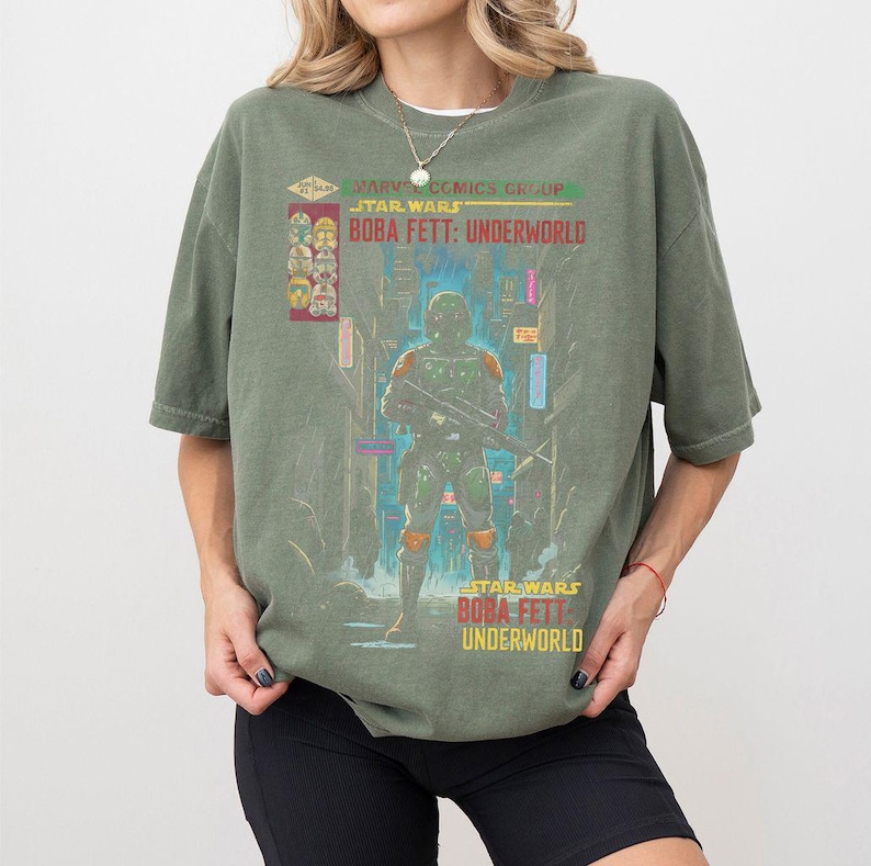 Puede incluir: Una camiseta verde oliva con un gr&aacute;fico de Boba Fett de Star Wars: Underworld. El dise&ntilde;o incluye el texto "Marvel Comics Group Star Wars Boba Fett: Underworld" y una colorida ilustraci&oacute;n del personaje en una ciudad futurista.