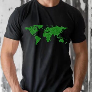 Op de afbeelding: Zwart T-shirt met een groene, gepixelde wereldkaart. De kaart, weergegeven in een digitaal raster, bedekt de borst. Het T-shirt heeft een ronde hals en korte mouwen.