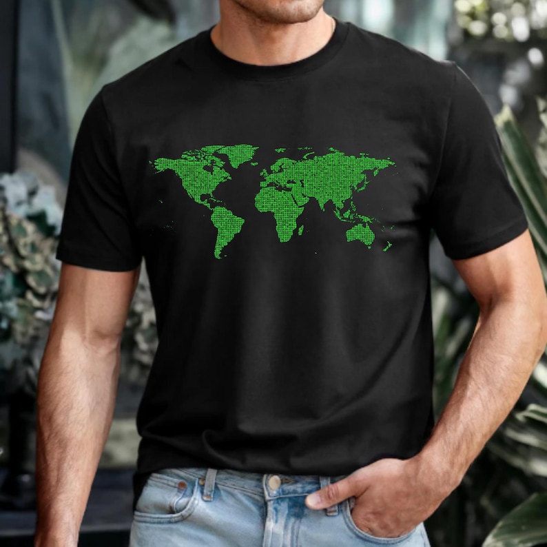 Op de afbeelding: Zwart T-shirt met ronde hals en een groen gepixeld wereldkaartontwerp. De afbeelding toont de continenten en landmassa's in een digitale stijl. Het T-shirt is gemaakt van een zacht materiaal.