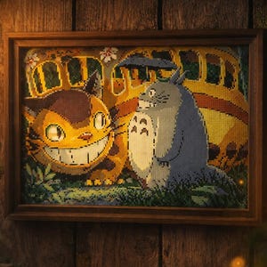 May include: Framed cross-stitch art featuring characters from the animated film, My Neighbor Totoro. The artwork depicts the Catbus and Totoro, with a smiling Catbus and Totoro holding an umbrella. The frame is brown, and the background is a wooden wall.