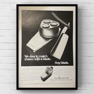 May include: Black and white advertisement for a Norelco VIP Tripleheader electric shaver. The ad features the shaver, a straight razor, and the text "We dare to match shaves with a blade."