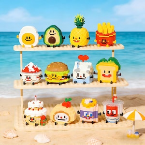 May include: A display of colorful, block-style food toys, including an egg, avocado, pineapple, fries, cake, burger, milk carton, toast, swiss roll, and drink. The toys are arranged on a multi-tiered shelf, with a beach and ocean backdrop.