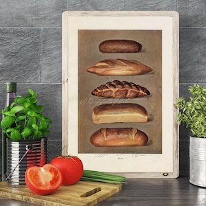 May include: A framed vintage print showcasing various types of bread. The image displays five different loaves, each with a unique shape and crust. The print is set against a neutral background, with a wooden frame. The image is a still life.