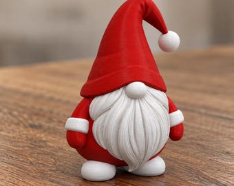 Könnte beinhalten: Eine kleine Wichtelfigur mit einer leuchtend roten Mütze, die an der Spitze einen weißen Bommel hat. Der Wichtel besitzt einen langen, strukturierten weißen Bart, eine runde weiße Nase, rote Ärmel mit weißen Bündchen und abgerundete weiße Füße.
