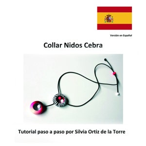 May include: A black cord necklace with two round pendants. The pendants are made of black, white, and red clay and have a zebra-like pattern. The necklace is called "Collar Nidos Cebra" and the image includes the text "Tutorial paso a paso por Silvia Ortiz de la Torre".