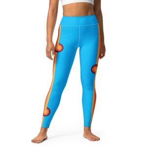 May include: Bright blue leggings with a high waist and a retro design. The leggings feature a vertical stripe of orange, red, and yellow on each side, with a circular design at the top and bottom of each stripe. The leggings are made of a stretchy material.