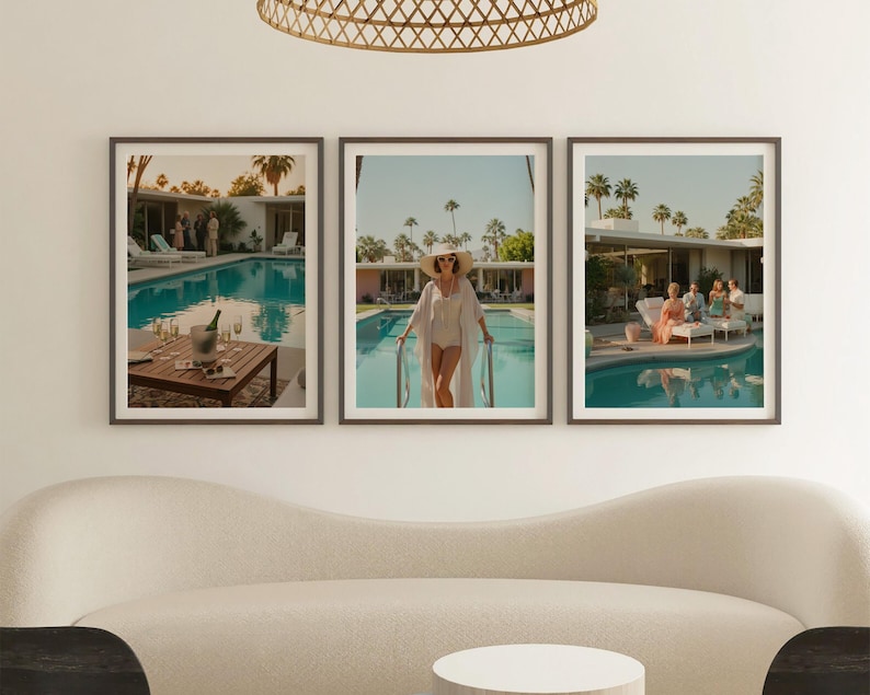 May include: Set of three framed art prints depicting a retro pool scene. The prints feature a turquoise pool, palm trees, and people enjoying the sun. One print shows a table with champagne. The frames are dark brown.
