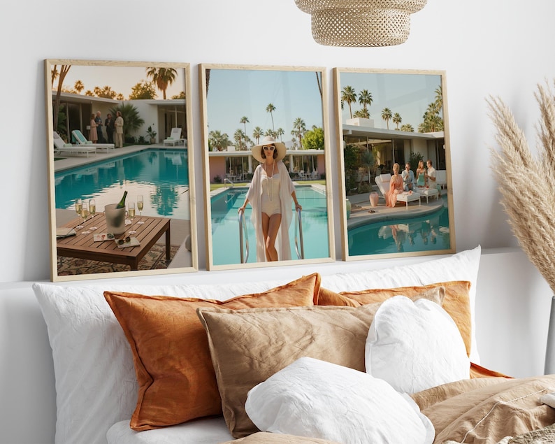 May include: Three framed prints depicting a retro poolside scene with a woman in a white swimsuit and hat, and a table with champagne. The prints are in light wood frames, and the scene is set in a mid-century modern style.