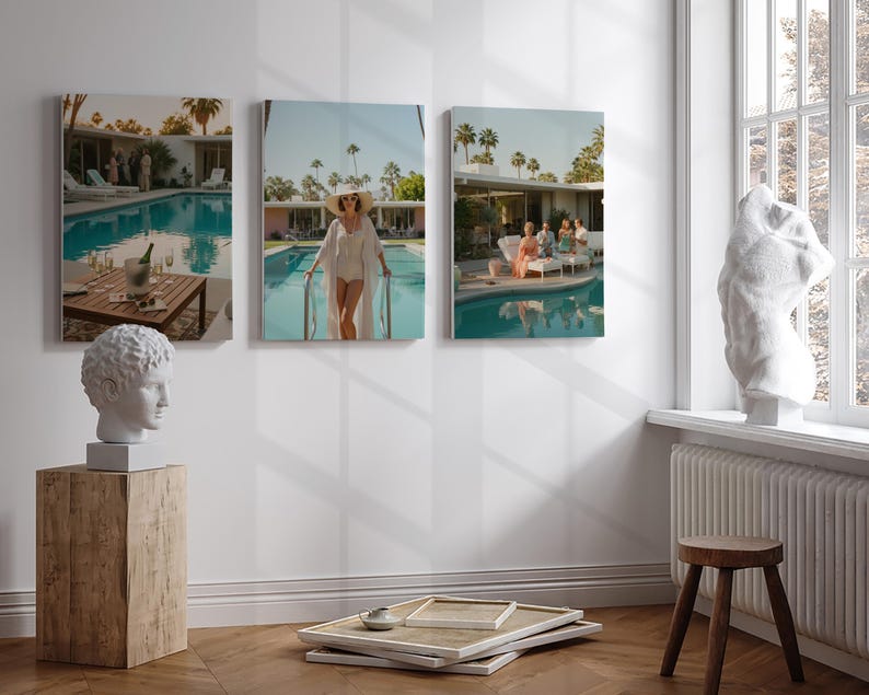 May include: Three framed canvas prints depicting scenes by a swimming pool. One shows a table with drinks, another a woman in a white outfit, and the third a group of people. A white bust and a wooden block are in the foreground.