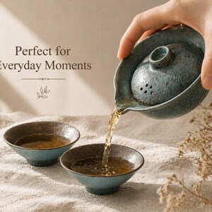 May include: A teal ceramic tea set with a teapot pouring tea into two small bowls. The teapot has a lid with small holes. The text "Perfect for Everyday Moments" is visible in the image.