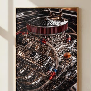 May include: Close-up of a framed print featuring a highly detailed, chrome-plated car engine. The engine has a red air filter, numerous pipes, and a polished finish. The image is framed in a light-colored wooden frame.