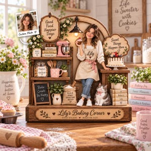 May include: A wooden baking corner display featuring a miniature kitchen scene with a person in an apron, a cat, shelves with jars, a mixer, books, and signs reading Lily's Baking Corner, Good Food Happier Days, and Sweet Things Happen Here.