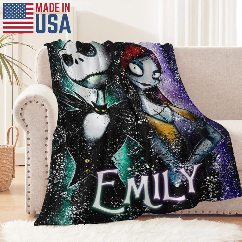 Peut inclure: Une couverture en peluche repr&eacute;sentant Jack Skellington et Sally de L'&Eacute;trange No&euml;l de Monsieur Jack, avec le nom "EMILY" en &eacute;criture blanche. La couverture est noire avec un motif color&eacute; et mouchet&eacute; et les mots "MADE IN USA" avec le drapeau am&eacute;ricain.