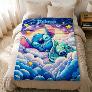 May include: A soft plush blanket featuring a blue character sleeping on a pillow amidst purple and blue clouds, a large yellow moon, and scattered yellow stars. The name Aubree is printed in light blue letters at the top of the blanket.
