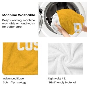 May include: A mustard yellow and white blanket featuring the text "COZY" in bold white letters. The blanket has advanced edge stitching, a lightweight texture, and is machine washable. The fabric appears soft and plush in appearance.