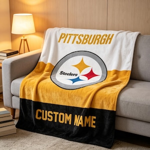 May include: A soft fleece throw blanket featuring a white top section with the word PITTSBURGH in yellow, a central Pittsburgh Steelers logo, a yellow middle section, and a black bottom section with the text CUSTOM NAME in yellow lettering.