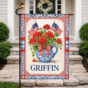 May include: A decorative garden flag featuring a blue and white floral vase filled with red flowers and two American flags. The flag has a red, white, and blue border and the name "GRIFFIN" is printed on the bottom.