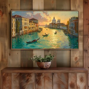 May include: A framed painting of a Venetian canal scene, featuring gondolas, buildings, and a domed church under a sunset sky. The artwork is displayed above a wooden cabinet, with a wooden bowl of greenery in front.