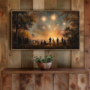 May include: A framed painting showing a fireworks display over a group of people. The artwork features a vibrant sky filled with bursts of light, silhouetted figures, and an American flag. The painting is displayed on a wooden cabinet.
