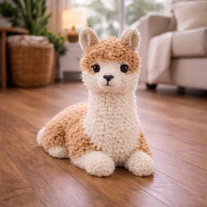 May include: A plush llama toy in a seated position. The toy has a cream-colored body with brown accents on its head and back. It features large, dark eyes and a soft, textured appearance, perfect for a child's room or nursery.
