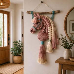 Peut inclure: Décoration murale en macramé représentant une tête de cheval rose. La crinière tressée est composée de fils crème et roses. Accents turquoise et longue gland. Suspendu à une branche en bois naturel.