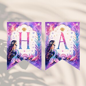 Puede incluir: Dos banderines con tem&aacute;tica de sirenas con las letras "HA". Cada bander&iacute;n presenta una ilustraci&oacute;n de sirena, conchas marinas y estrellas de mar sobre un fondo morado y turquesa. Dise&ntilde;ado para una fiesta.