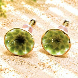 May include: Two round cabinet knobs featuring a concave, flower-like shape with a glossy light green finish, a dark green center, and a metallic gold-toned rim. Each knob includes a threaded metal bolt and a small nut for installation.