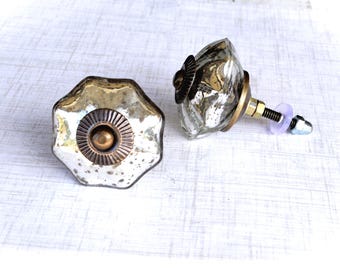 May include: Two decorative cabinet knobs with a vintage aesthetic. The knobs have a multifaceted, silver-toned glass design with brass and bronze accents. One knob is shown from the front, the other from the side, with the screw and hardware visible.