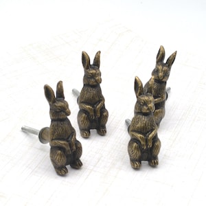 May include: A set of three ceramic mugs with a speckled, matte finish. The mugs are in shades of cream, light gray, and dark gray. Each mug has a simple, minimalist design and a rounded handle.