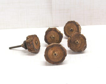 May include: A collection of five rustic wooden cabinet knobs. Each knob features a natural wood slice design with a brass-colored center. The knobs are ideal for adding a touch of nature-inspired decor to furniture.