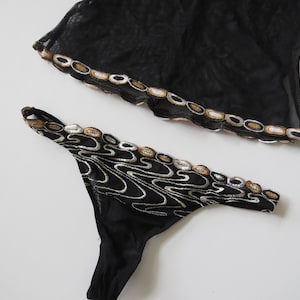 Puede incluir: Una taza de cer&aacute;mica blanca con un asa negra y el texto "But First, Coffee" en negro y negrita. La taza est&aacute; sobre una superficie blanca. La taza mide aproximadamente 10 cm de alto.