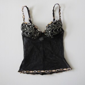 Puede incluir: Una taza de cer&aacute;mica blanca con un asa negra y el texto "But First, Coffee" en negro, con una fuente de estilo manuscrito. La taza est&aacute; sobre una superficie blanca.