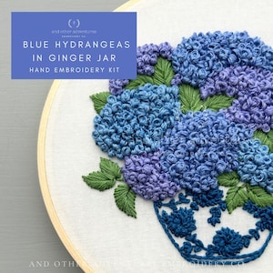 May include: A hand embroidery kit featuring a blue hydrangea flower arrangement in a blue and white ginger jar. The kit includes all the materials needed to create the embroidery, including embroidery floss, needles, and fabric.