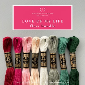 May include: A floss bundle for embroidery projects, labeled "Love of My Life" with eight spools of DMC embroidery floss in various colors, including red, pink, beige, white, green, and dark green.