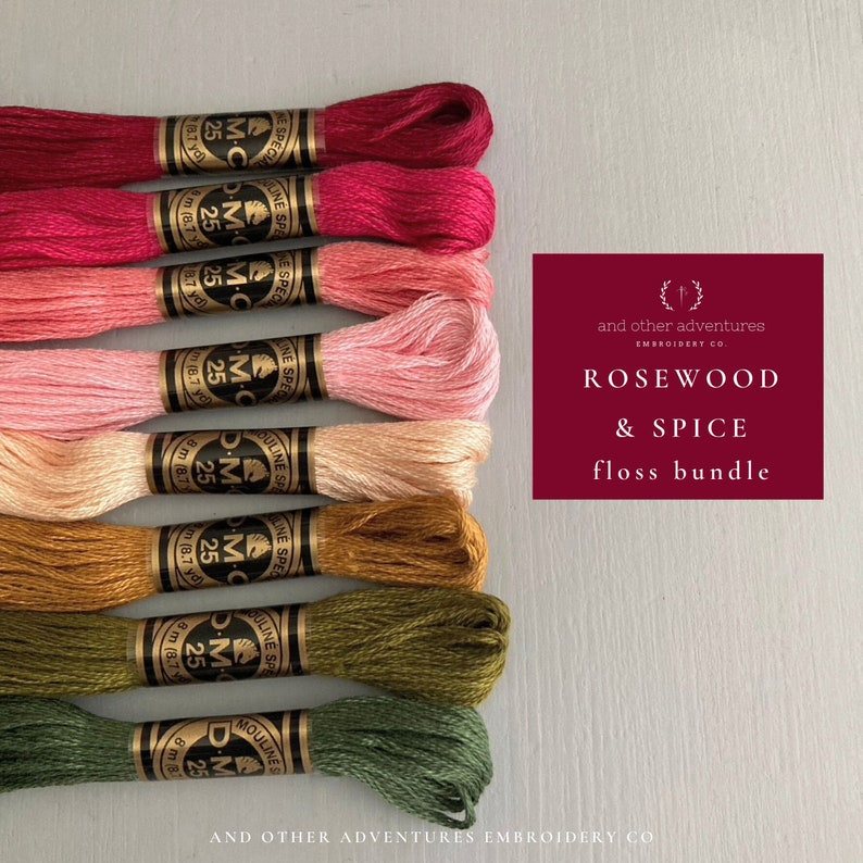 May include: A floss bundle called "Rosewood & Spice" by And Other Adventures Embroidery Co. The bundle includes eight skeins of DMC embroidery floss in shades of red, pink, orange, brown, and green.