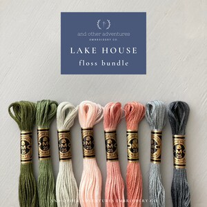 May include: A set of eight DMC embroidery floss spools in various shades of green, beige, pink, and gray. The spools are labeled with the DMC number and the text "DMC Special Mouline".