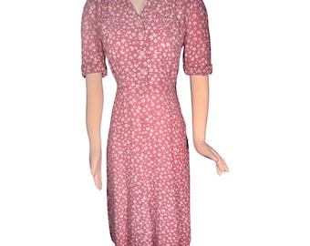 Dammig rosa klänning med hjärtformade fickor från 1940-talet