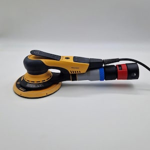 Könnte beinhalten: Ein gelb-schwarzer Elektroschleifer mit rundem Schleifpad. Der Schleifer hat einen schwarzen Griff und ein Netzkabel. Er hat einen grauen, blauen und roten Aufsatz. Geeignet zum Schleifen von Holz und anderen Materialien. Misst etwa 30 cm in der Länge.