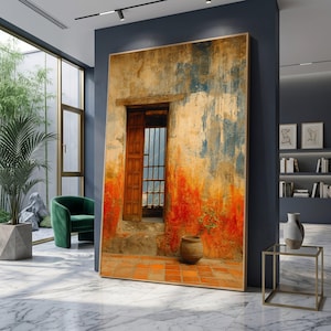 May include: Large framed artwork showing a distressed wall with a wooden window and door. The wall displays vibrant colours of orange, red, and blue, with a small potted plant. The artwork is displayed in a modern interior setting.