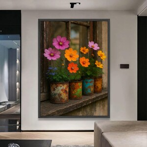Pode incluir: Impressão emoldurada com flores de cosmos coloridas em latas recicladas numa janela desgastada. As flores são rosa, laranja e amarelas, contrastando com as latas enferrujadas. A cena irradia uma atmosfera rústica e charmosa.