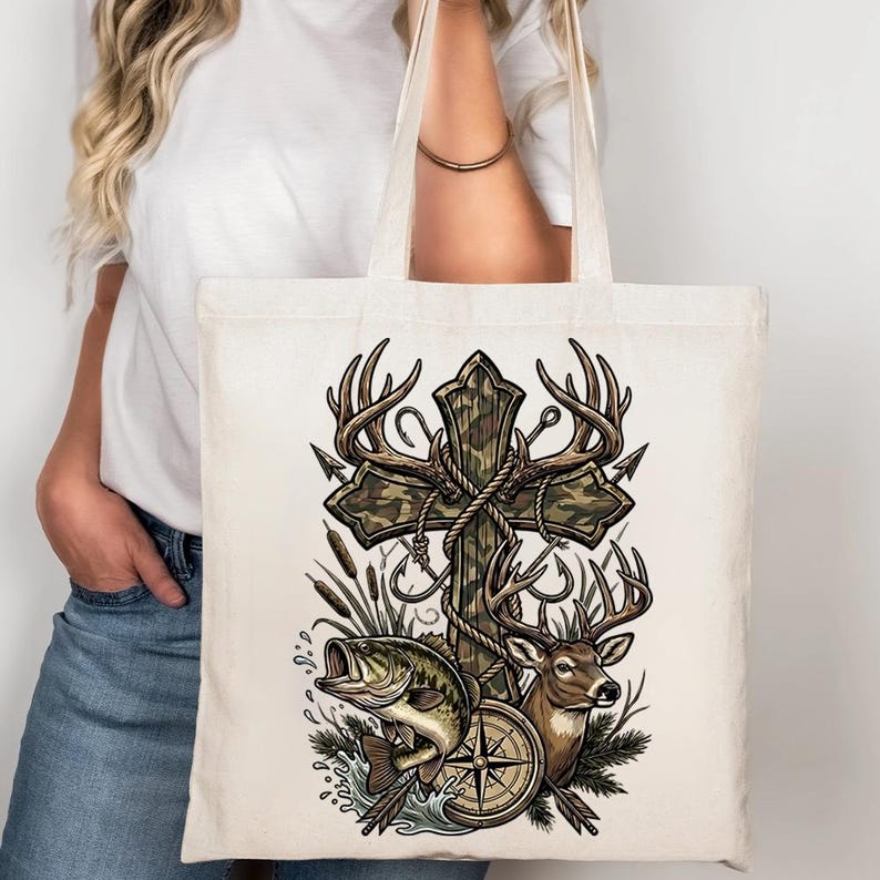 May include: Cream-colored tote bag featuring a cross design with deer antlers, camouflage, and rope accents. A fish, deer, and compass are also depicted. The bag is made of a durable fabric.