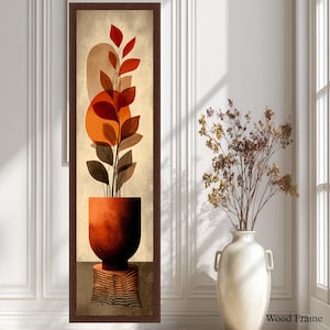 May include: Abstract art print featuring a terracotta-colored plant in a matching pot, set against a beige background with orange and brown geometric shapes. The artwork is framed in a dark brown wood frame. The text "Wood Frame" is visible.