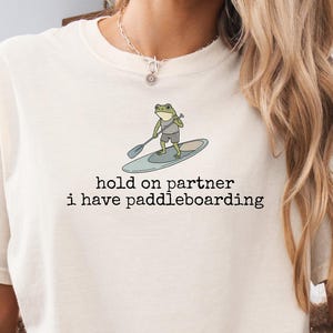 Regalo único para paddleboarding, camiseta divertida de rana para paddleboarding, camiseta de aventura de rana para SUP, camiseta de aventura acuática de rana, camiseta de rana para paddleboarding natural