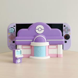 Könnte beinhalten: Eine lila-weiße Nintendo Switch-Hülle mit einem Gebäudedesign, einem kleinen Spielautomaten und passenden Controller-Tasten. Das Gebäude hat ein lila Dach mit weißem Logo und eine blau-weiße Tür. Der Controller hat einen schwarzen Joystick.