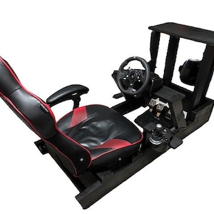 Könnte beinhalten: Schwarzes und rotes Rennsimulator-Cockpit mit Lenkrad, Pedalen und Schalthebel. Der Sitz ist schwarz mit roten Akzenten. Der Rahmen besteht aus schwarzem Holz.