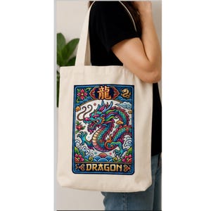 May include: Cream-colored tote bag featuring a colorful dragon design. The dragon is depicted in shades of blue, green, and pink, with the word "DRAGON" below. The design is framed with a blue border and floral accents.