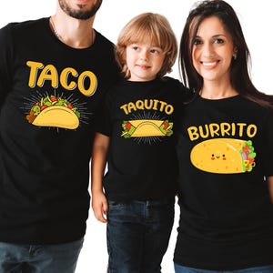 May include: Three black t-shirts with food-themed designs. One shirt says "TACO" with a taco graphic, another says "TAQUITO" with a taquito graphic, and the third says "BURRITO" with a burrito graphic. All designs are in yellow and feature cartoon-style food illustrations.